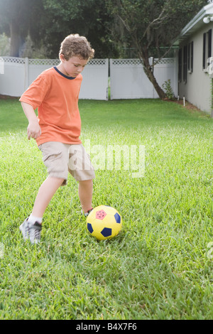 Jungen spielen Fußball im Hinterhof Stockfoto