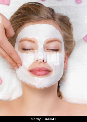 Junge Frau, die immer Gesichts Spa-Behandlung Stockfoto