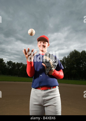 Baseballspieler, die Kugel in die Luft werfen Stockfoto