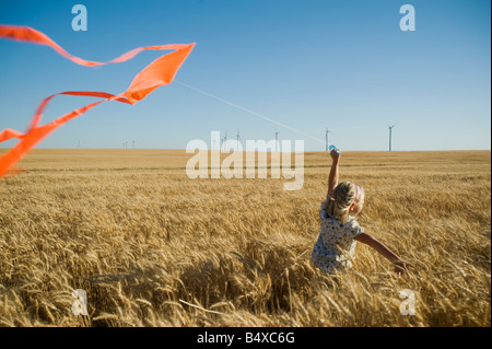 Mädchen mit Kite am Windpark laufen Stockfoto
