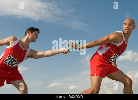 Läufer übergeben-Baton Teamkollegen Stockfoto