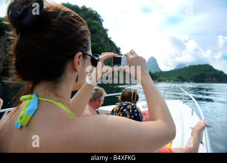 EIN TOURIST AUF EINE BOOTSFAHRT IN DER NÄHE VON SOUFRIÈRE ST LUCIA FOTOGRAFIERT DIE ANSICHT MIT DEN BERGEN PETIT LINKS UND GROS PITON AUF DEN HORIZO Stockfoto