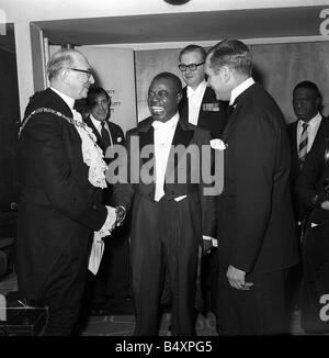 Louis Satchmo Armstrong teilt Dez. 1956 an das musikalische London-Benefiz-Konzert in der Royal Festival Hall Louis einen Witz in Hiis Umkleidekabine mit The Lord Mayor of London L Sir Cullum Welch und Sir Laurence Olivier Extreme rechts Stockfoto