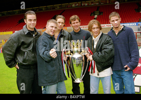 Mitglieder der Popgruppe nehmen, links nach rechts Robbie Williams Gary Barlow Howard Donald Mark Owen und Jason Orange mit Bryan Robson von Manchester United und die Premiership Trophäe im Old Trafford Juli 1993 Stockfoto