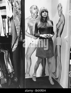 Achtzehn Jahre alten Schwester Jenny Boyd von Pattie Boyd in John Stephens Boutique für Mädchen Carnaby Street London In sind die Umkleidekabinen es voller Länge Bilder der Männer an den Wänden für die Mädchen zu betrachten Stockfoto