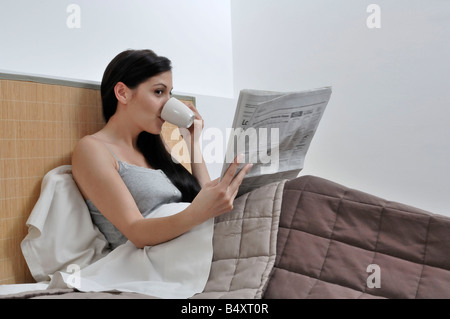 Frau liest Papier in ihrem Bett Stockfoto