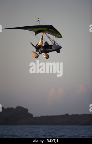 Microlite fliegen über das Meer am Strand von weißen Felsen in Portrush bei Sonnenuntergang Northern ireland Stockfoto