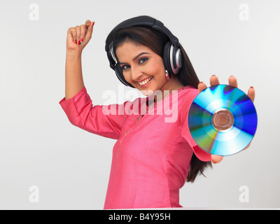 asiatische Frau indischer Herkunft trägt ein pinkes Top und Musik genießen Stockfoto