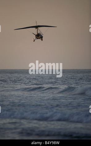 Microlite fliegen über das Meer am Strand von weißen Felsen in Portrush bei Sonnenuntergang Northern ireland Stockfoto