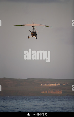 Microlite fliegen über das Meer am Strand von weißen Felsen in Portrush bei Sonnenuntergang Northern ireland Stockfoto