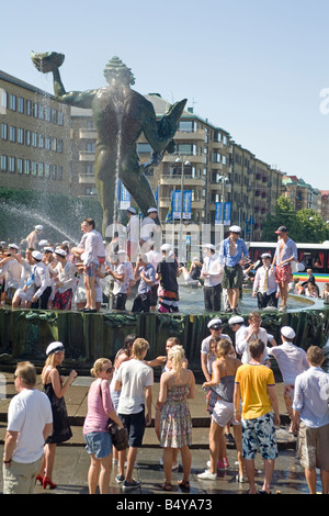 Göteborg Schweden Menschenmassen versammelt am Götaplatsen Quadrat während Hallo Schule Abschlusstag einige bekommen erfrischenden Spritzer in Brunnen Stockfoto
