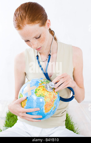 junge Frau mit Stethoskop Untersuchung Globus Stockfoto