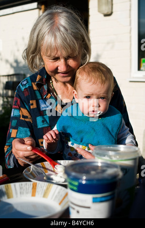 Großmutter Fütterung Joghurt an ihren Enkel beim Frühstück. Stockfoto