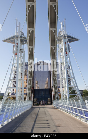 Quay West Building, betrachtet über die Millennium Bridge, Salford Quays, die sich auch in den Fenstern spiegelt Stockfoto