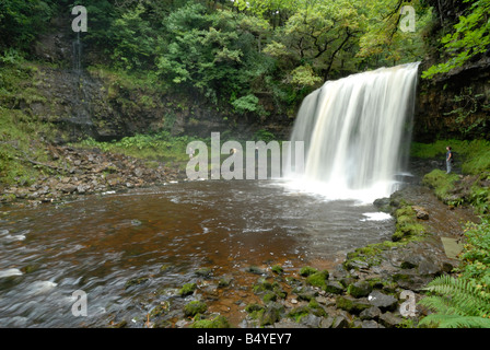 Sgwd yr Eira Wasserfall in den Brecon Beacons mit vier Personen zu Fuß rund um die Rückseite ist Stockfoto