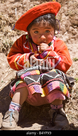 Kleine peruanische Mädchen Kleinkind trägt traditionelle Tracht native Anden oder Kleid streckt ihre Hand schüchtern für ein süßes. Stockfoto