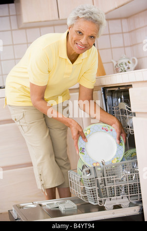 Frau laden Geschirrspüler Stockfoto