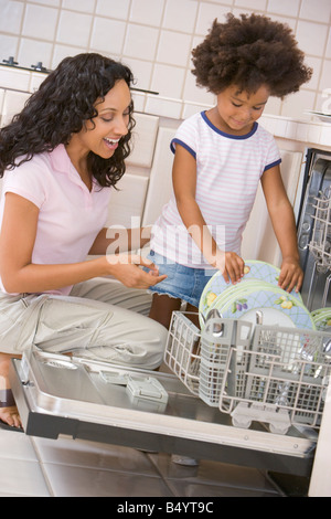 Mutter und Tochter laden Geschirrspüler Stockfoto