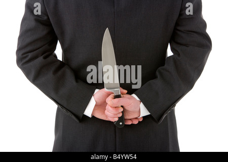 Geschäftsmann mit Messer hinter seinem Rücken Stockfoto