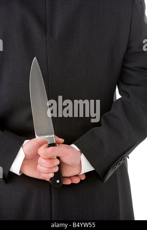 Geschäftsmann mit Messer hinter seinem Rücken Stockfoto