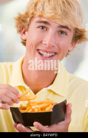 Teenager essen Pommes frites Stockfoto