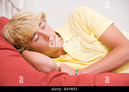 Teenager auf Bett liegend Stockfoto