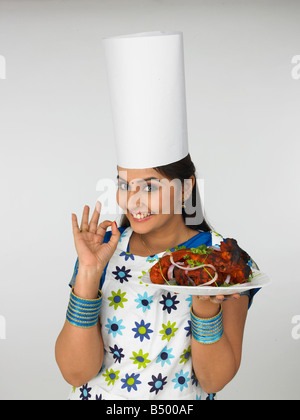 eine attraktive asiatische Köchin reden über ihr Handy Stockfoto