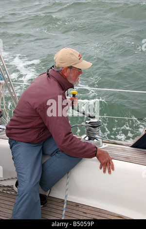 Reife Maln Drehgriff auf einer Winde auf einer Segel-Yacht Stockfoto