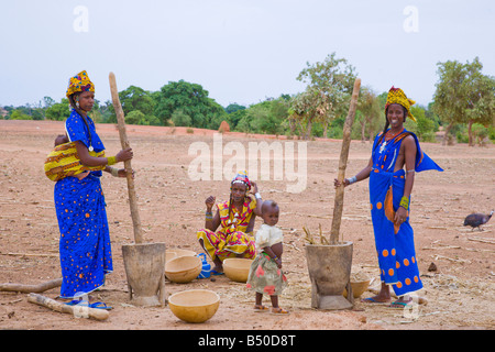 Fulani-Frauen in einem Dorf im südwestlichen Niger Pfund Hirse im Laufe des Tages, die sie dann zum Abendessen in Polenta machen werden. Stockfoto