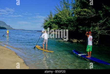 Paddel-Boarder gehen von der Mündung des Hanalei River in Hanalei Bay auf Kauai Stockfoto