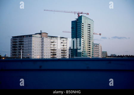 Hochhäuser im East End über den oberen Teil der blauen Zaun laufen rund um die Baustelle der Olympischen Spiele in London zu sehen. Stockfoto