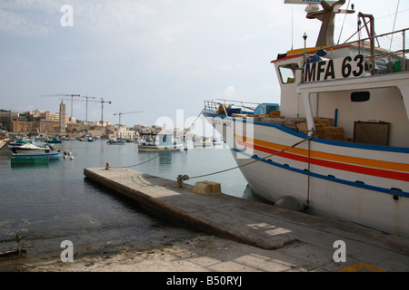 Ein Fischerboot gefesselt am Kai im Hafen von Marsaskala, Malta. Stockfoto