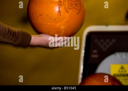 Abholung eine Bowling-Kugel Stockfoto