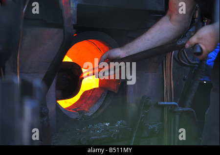 Schürt das Feuer in einer alten Dampflokomotive Stockfoto