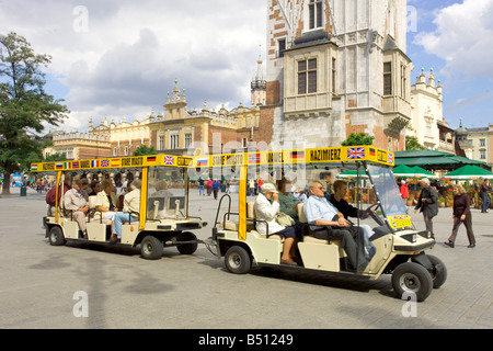 Eine elektrische Auto Stadtrundfahrt im Main Market Square von Krakau in Polen mit der Basis der Rathausturm rechts. Stockfoto