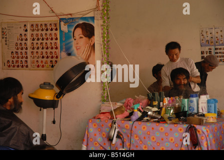 Ein Mann bekommt einen Haarschnitt im ländlichen China. Stockfoto