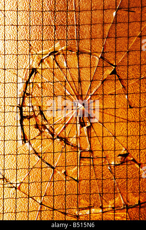 Einschussloch im drahtgebundenen Fensterglas Stockfoto