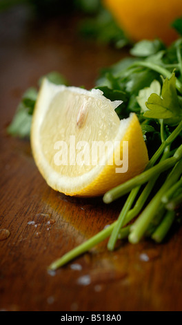 Essen-stock-Fotografie - eine Scheibe Zitrone und Haufen von Blattpetersilie auf einem dunklen Holztisch. Stockfoto