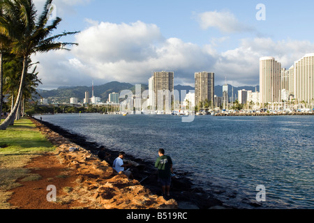 Fischer auf dem felsigen Wellenbrecher, Magic Island, Hawaii Stockfoto