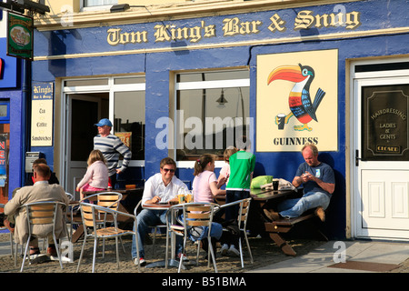 Menschen sitzen vor Tom King Bar & Snug in Clifden, Irland Stockfoto