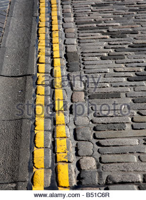 Doppelte gelbe Linien auf gepflasterten Straße Stockfoto