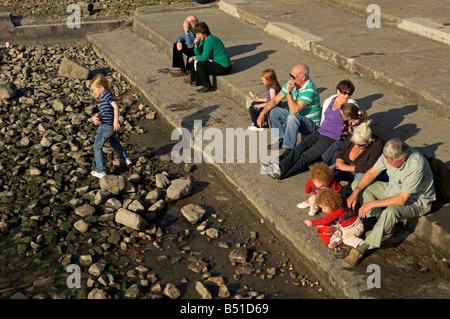 Menschen sitzen auf Stufen von englischen Küste Clevedon North Somerset Familientag Stockfoto