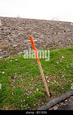 Ein Holzpfahl auf der Oberseite rot lackiert in den Boden gesteckt Stockfoto