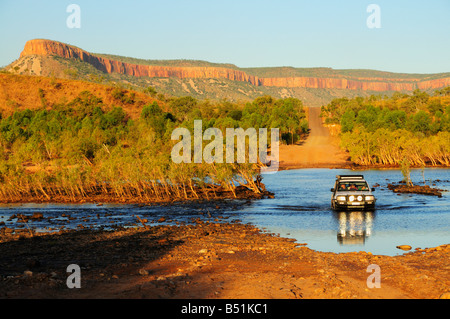 SUV Kreuzung Pfingsten Fluss mit Cockburn Ranges im Hintergrund, Gibb River Road, Kimberley, Western Australia, Australien Stockfoto