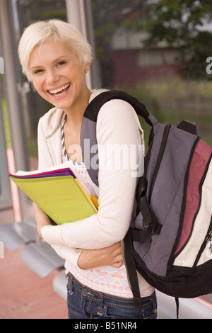 Junge Studentin an Bushaltestelle Stockfoto