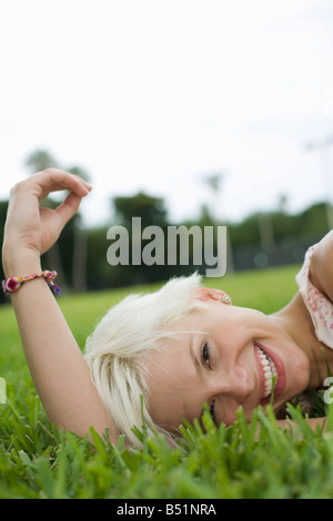 Junge Frau im Grass liegen Stockfoto