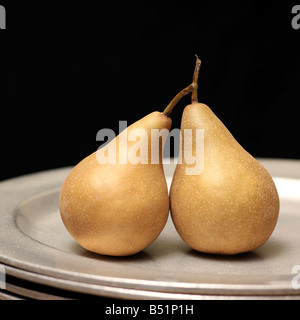 Bosc Birnen auf Stapel von Silberschalen Stockfoto