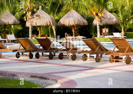 Poolliegen aufgereiht neben Pool Stockfoto