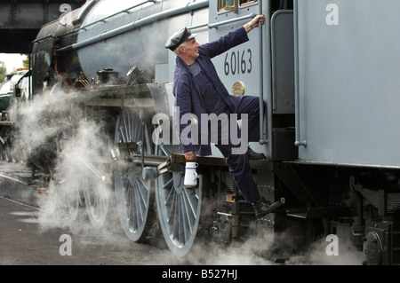 Ein Dampfmaschine Fahrer steigt in seine Kabine. Der Zug ist 60163 Tornado auf der Great Central Railway. Stockfoto