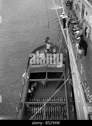 Die Crew der County-Klasse Kreuzer HMS London Einnahme an Bord Vorräte und Munition aus einem Lastkahn nachdem sie beschädigt worden war Stockfoto